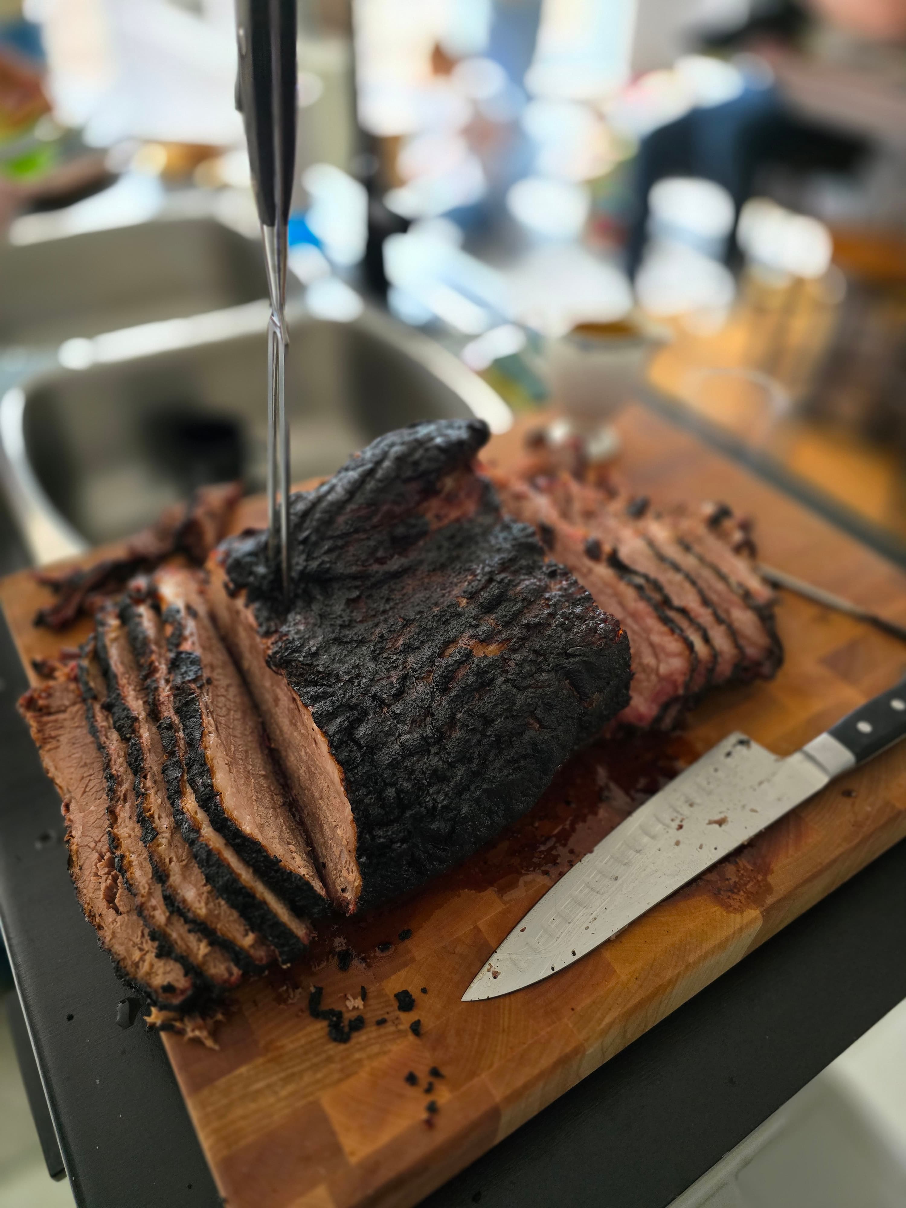 Sliced smoked brisket on a wooden cutting board