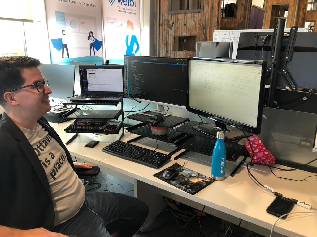 Brandon in the Welbi office in a shirt reading "Ottawa is a place"